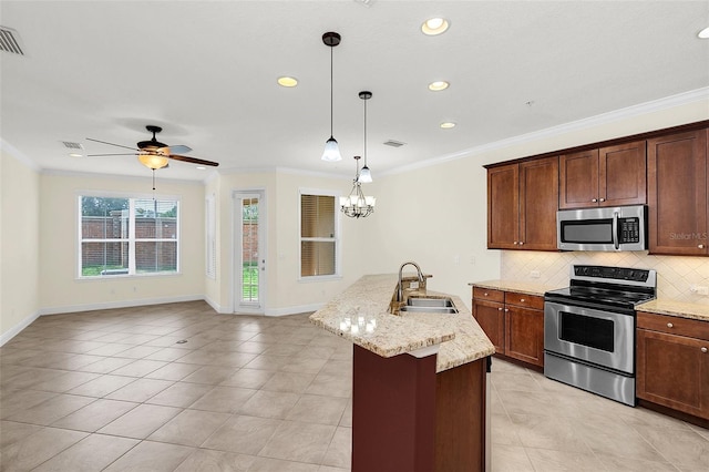 kitchen featuring sink, decorative light fixtures, stainless steel appliances, a kitchen island with sink, and backsplash