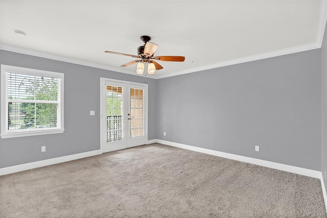 carpeted empty room with ornamental molding, ceiling fan, and french doors