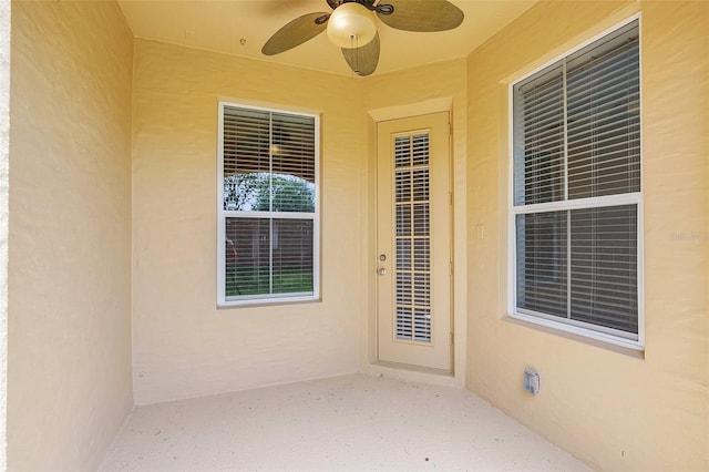 entrance to property with a patio and ceiling fan