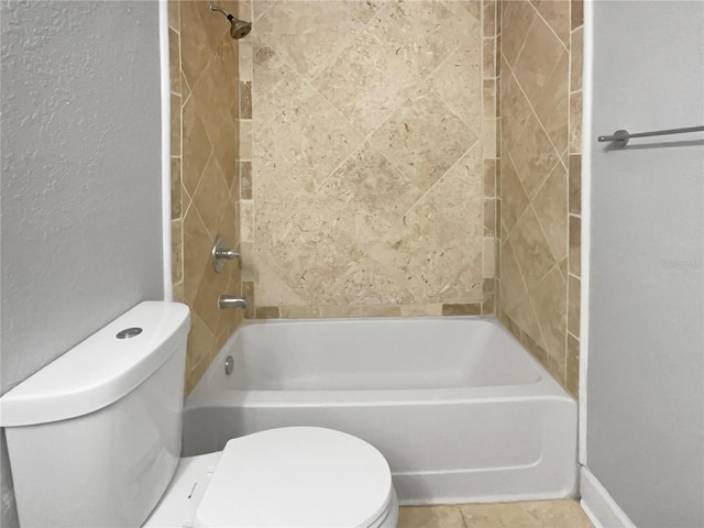 bathroom featuring tiled shower / bath and toilet