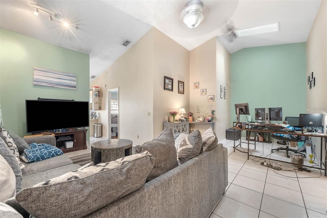 living room with light tile patterned floors, vaulted ceiling, and ceiling fan