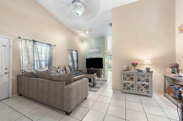 living room with ceiling fan, light tile patterned floors, and high vaulted ceiling