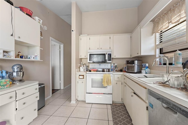 kitchen featuring stainless steel appliances, white cabinetry, sink, and light tile patterned floors