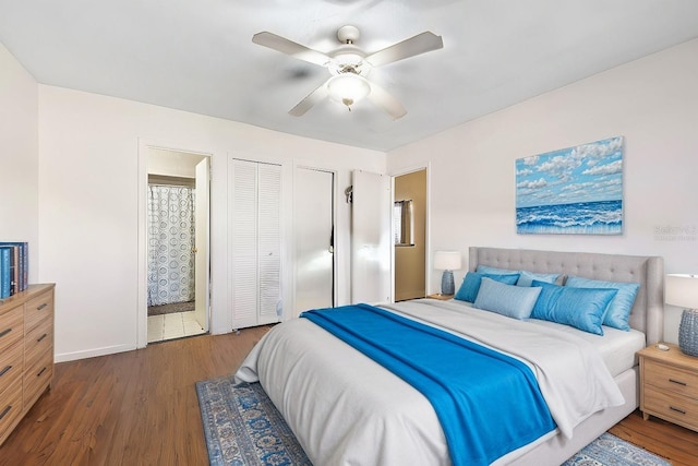 bedroom featuring ensuite bath, dark wood-type flooring, and ceiling fan