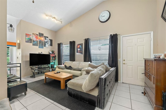 tiled living room featuring a wealth of natural light and high vaulted ceiling