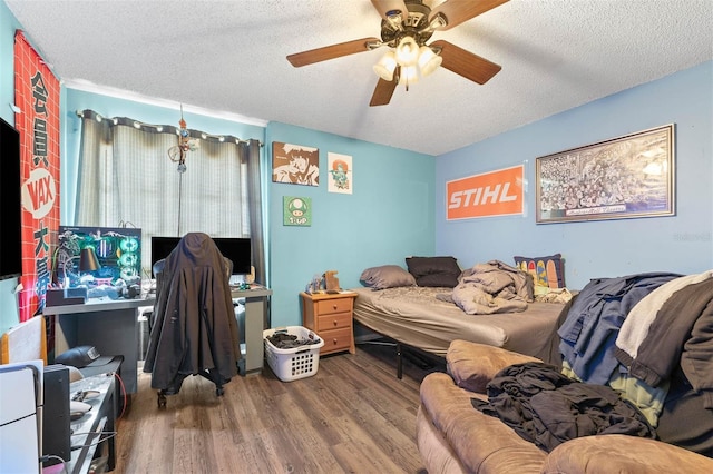 bedroom featuring ceiling fan, wood-type flooring, and a textured ceiling