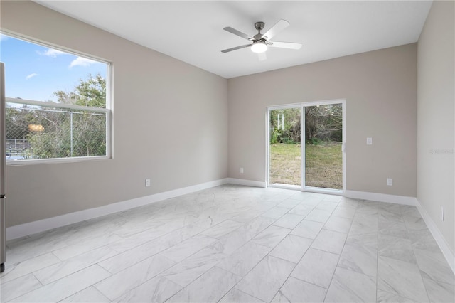 empty room with ceiling fan and a healthy amount of sunlight