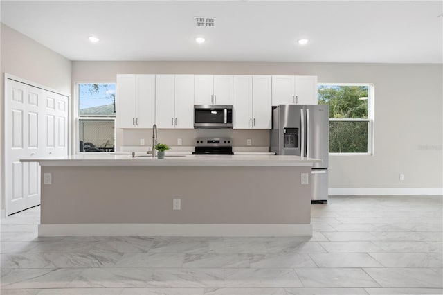 kitchen featuring white cabinetry, appliances with stainless steel finishes, sink, and an island with sink