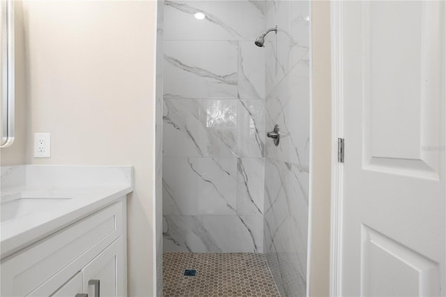 bathroom with vanity and a tile shower