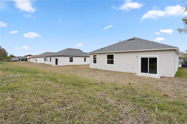 rear view of house featuring a lawn