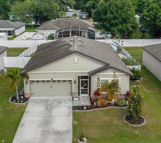 view of front of home featuring a garage, a front yard, and glass enclosure