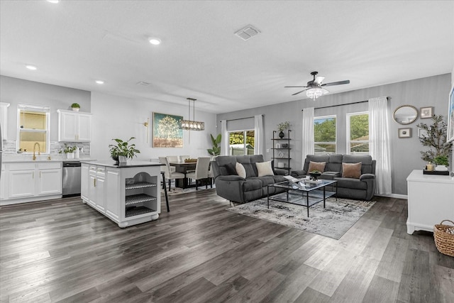 living room with dark wood-type flooring, sink, and ceiling fan