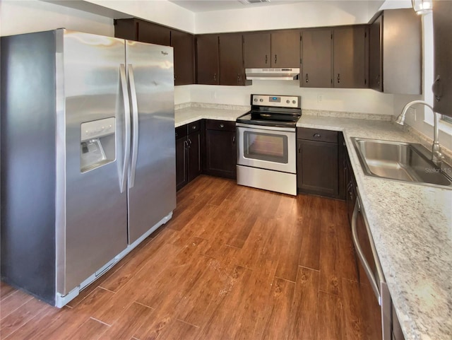 kitchen with dark brown cabinetry, appliances with stainless steel finishes, dark hardwood / wood-style floors, and sink