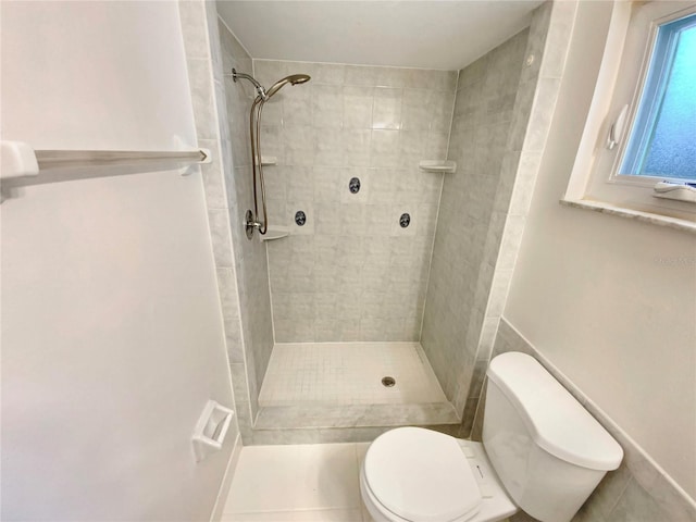 bathroom with tiled shower and toilet