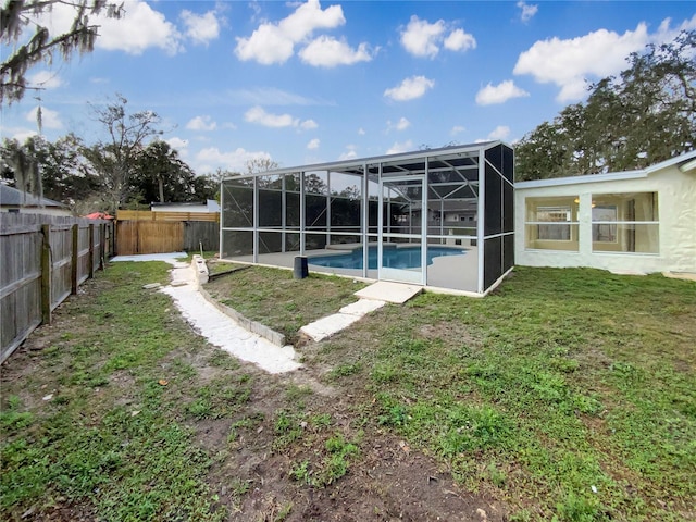 back of house with a fenced in pool, a lanai, and a lawn