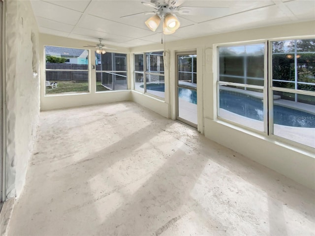 unfurnished sunroom featuring a drop ceiling and ceiling fan