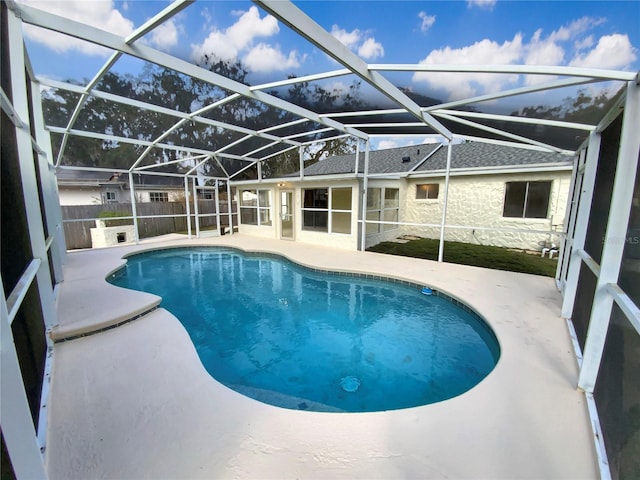 view of swimming pool featuring a lanai and a patio area