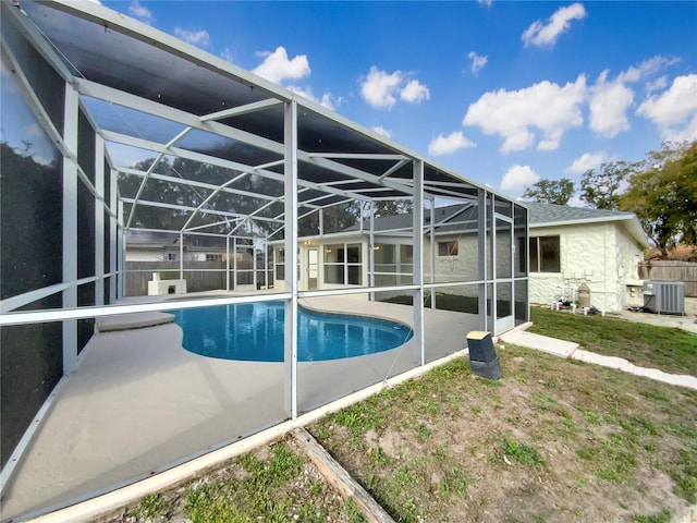 view of pool with central AC, glass enclosure, and a patio area