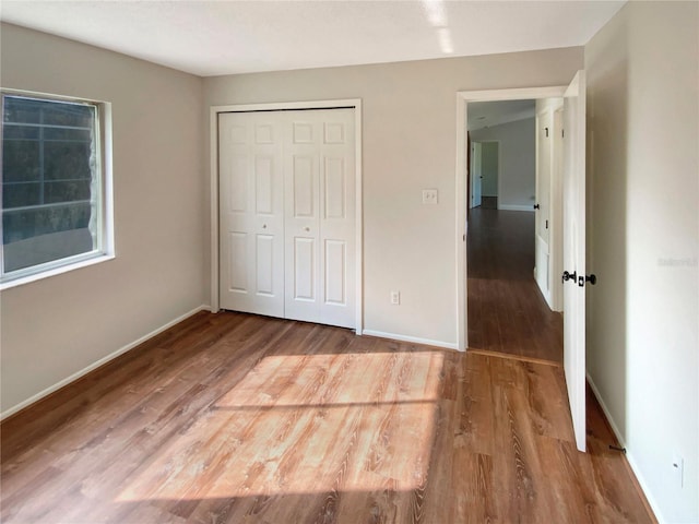 unfurnished bedroom with hardwood / wood-style flooring and a closet