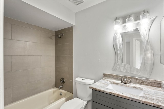 full bathroom with tiled shower / bath, vanity, and toilet