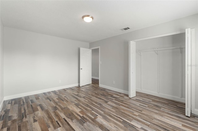 unfurnished bedroom featuring hardwood / wood-style floors and a closet