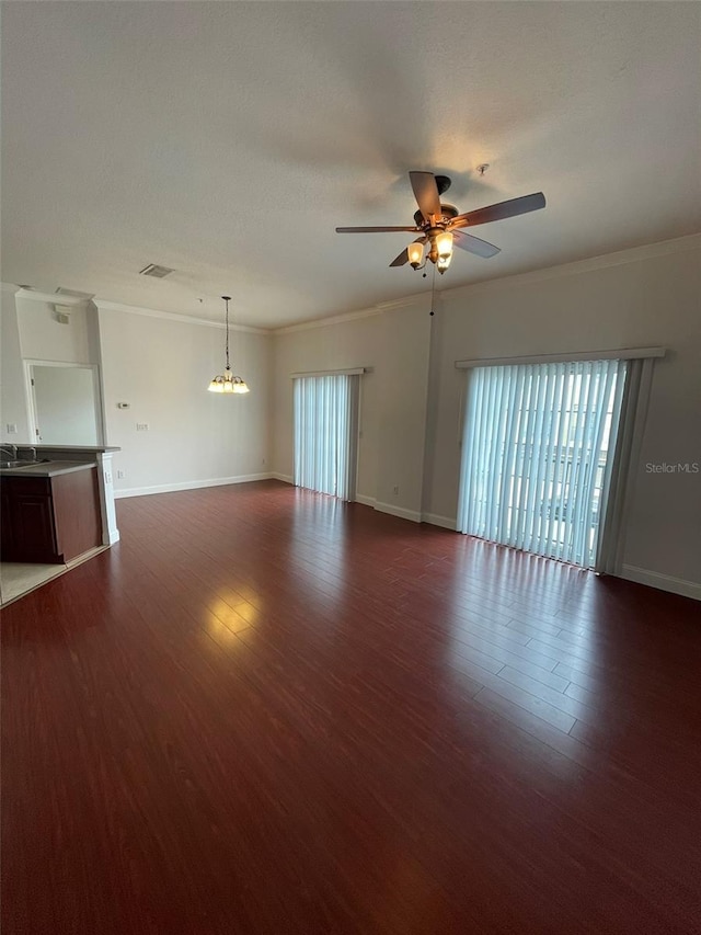 unfurnished room with crown molding, sink, dark wood-type flooring, and ceiling fan with notable chandelier