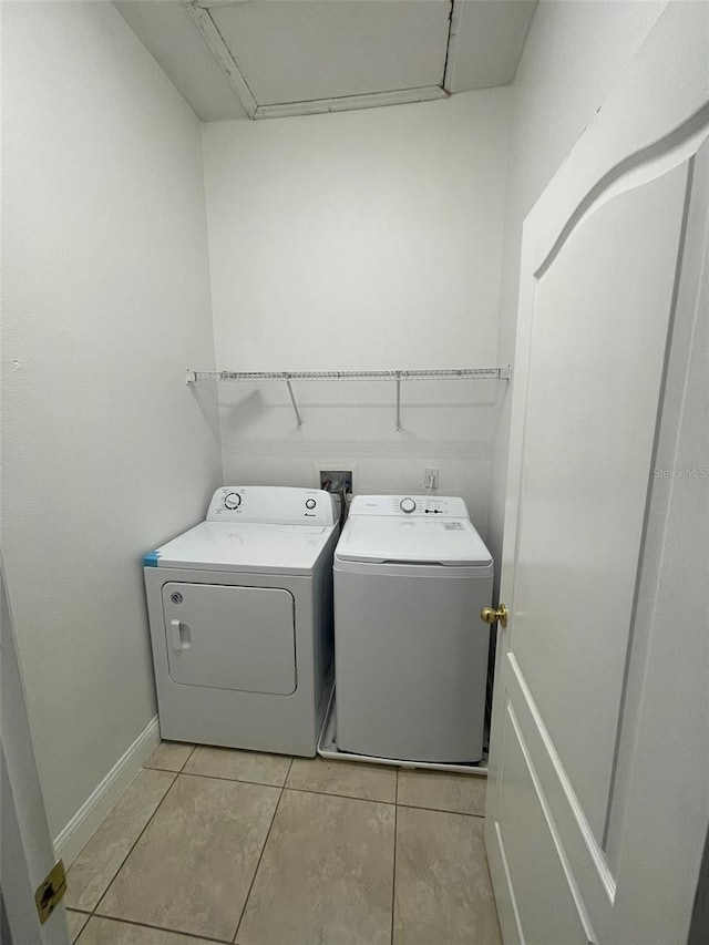 washroom featuring washing machine and dryer and light tile patterned floors