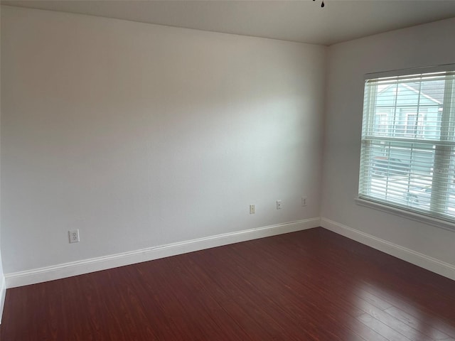 unfurnished room featuring dark hardwood / wood-style floors and a wealth of natural light