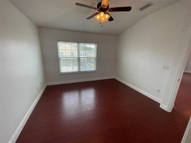 spare room with dark wood-type flooring and ceiling fan