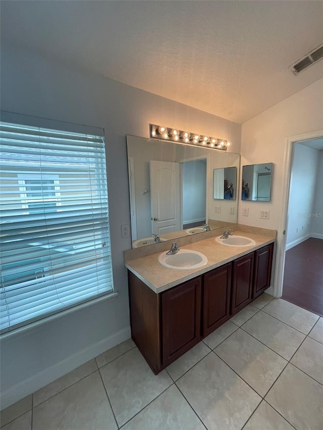 bathroom featuring vanity, tile patterned flooring, and a textured ceiling