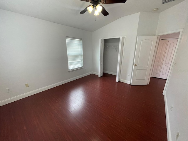 unfurnished bedroom with dark wood-type flooring, a closet, ceiling fan, and vaulted ceiling