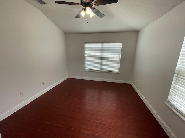 unfurnished room featuring dark wood-type flooring and ceiling fan