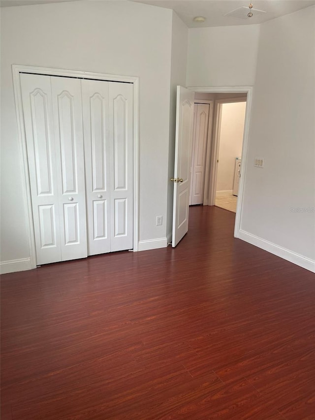 unfurnished bedroom featuring dark hardwood / wood-style flooring and a closet