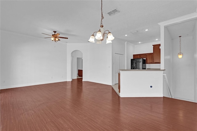 unfurnished living room featuring visible vents, arched walkways, dark wood finished floors, and ceiling fan with notable chandelier