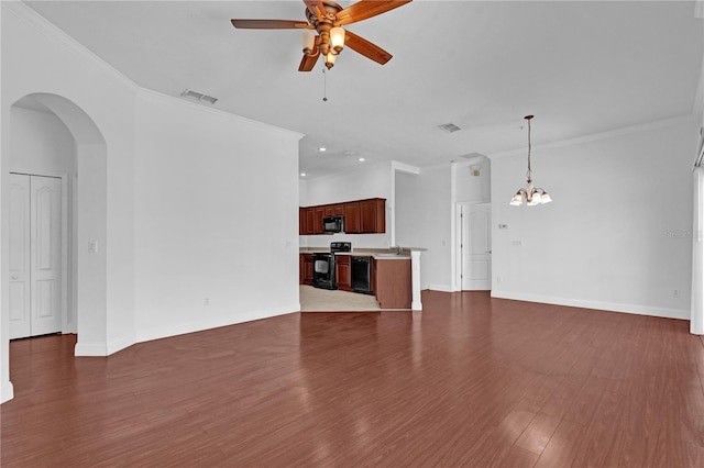 unfurnished living room featuring ceiling fan with notable chandelier, visible vents, baseboards, dark wood finished floors, and crown molding