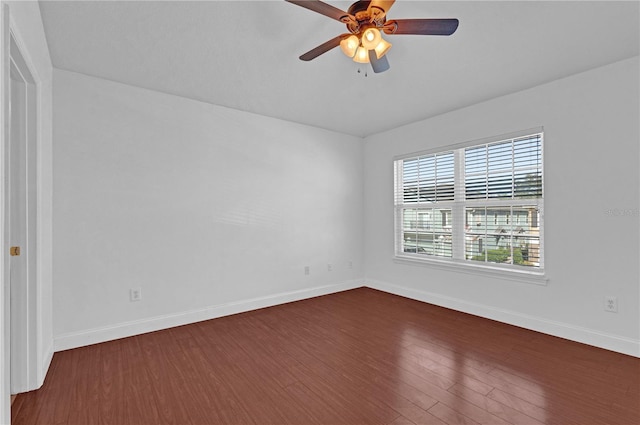 unfurnished room featuring ceiling fan, baseboards, and dark wood-type flooring