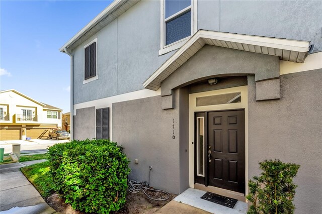 view of exterior entry featuring stucco siding