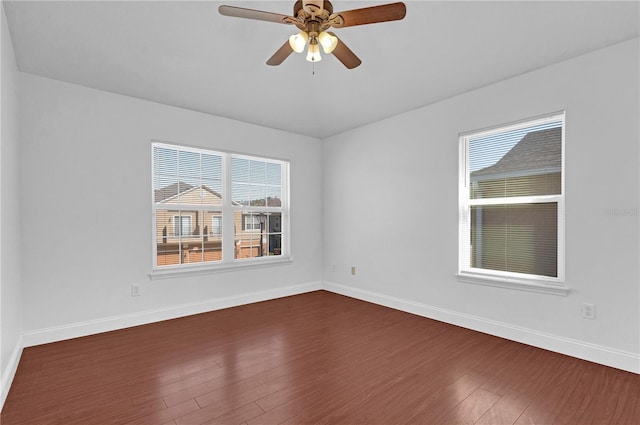 spare room with dark wood-style floors, ceiling fan, and baseboards