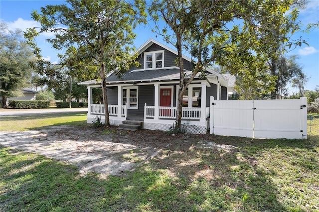 view of front of house with covered porch and a front lawn