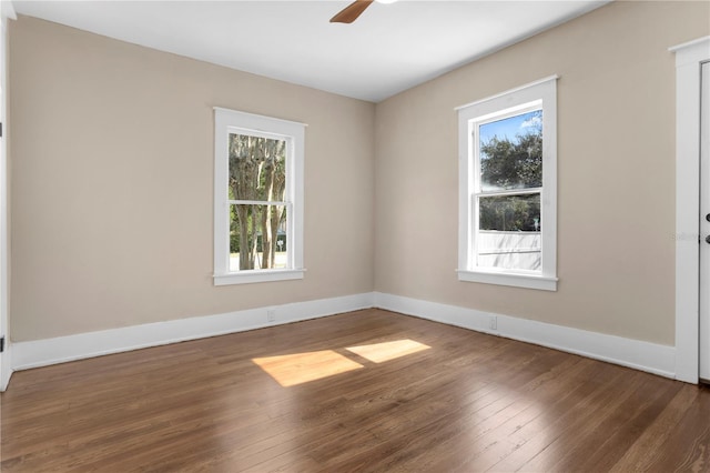 empty room with dark hardwood / wood-style floors and ceiling fan