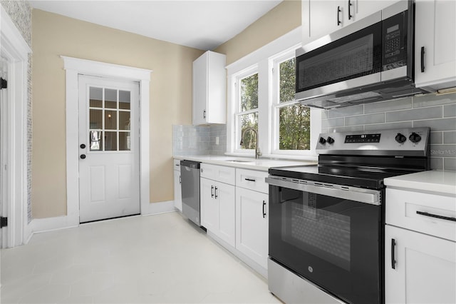 kitchen featuring tasteful backsplash, sink, stainless steel appliances, and white cabinets