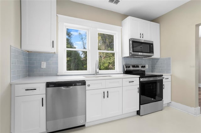 kitchen with white cabinetry, appliances with stainless steel finishes, sink, and backsplash