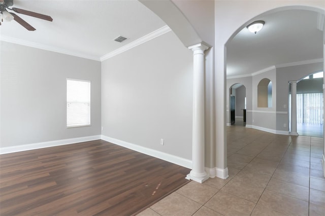 empty room featuring ornate columns, crown molding, a wealth of natural light, and ceiling fan