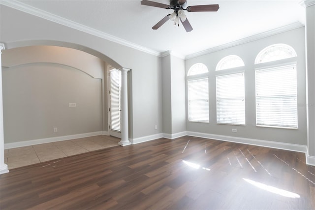 unfurnished room with ornate columns, crown molding, ceiling fan, and dark hardwood / wood-style flooring