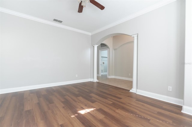 spare room featuring dark hardwood / wood-style flooring, crown molding, decorative columns, and ceiling fan