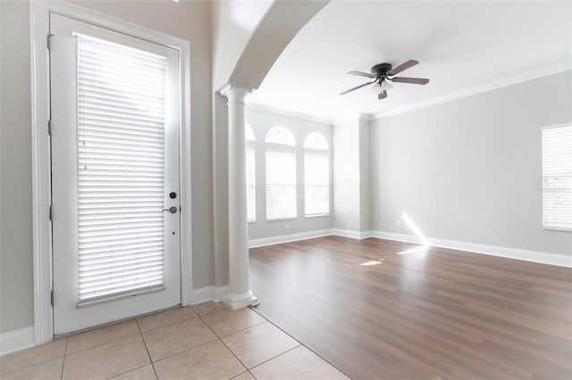 interior space with ornate columns, crown molding, and ceiling fan