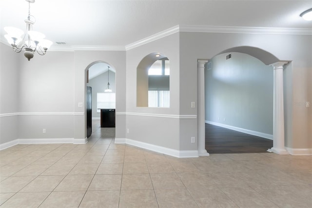 tiled empty room with ornate columns, crown molding, and a notable chandelier