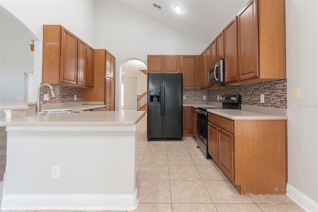 kitchen featuring light tile patterned flooring, sink, backsplash, kitchen peninsula, and stainless steel appliances