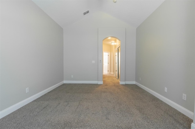 carpeted empty room with lofted ceiling