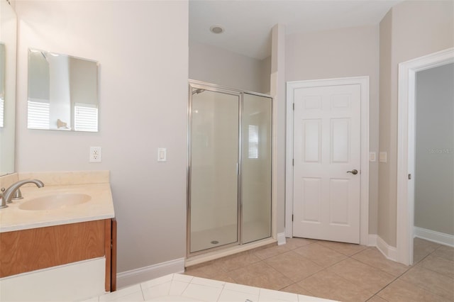 bathroom featuring vanity, a shower with shower door, and tile patterned flooring